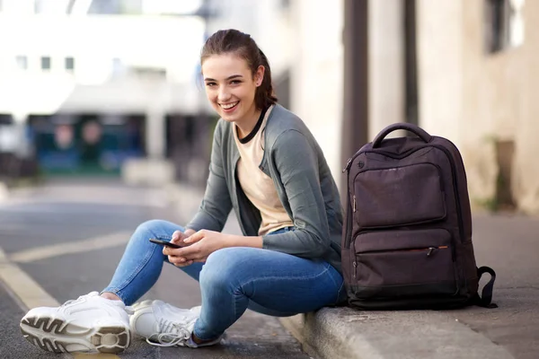 Retrato Uma Estudante Sorrindo Sentada Chão Lado Fora Segurando Celular — Fotografia de Stock