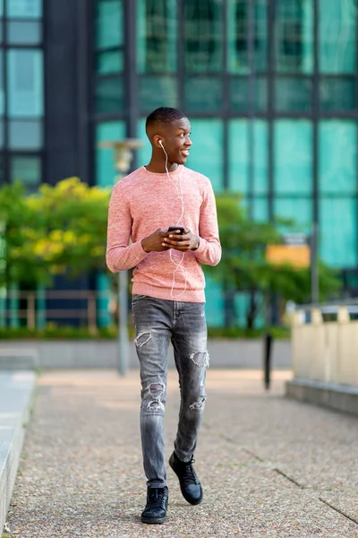 Pełna Długość Portret Młody Czarny Człowiek Chodzenie Telefonem Komórkowym Słuchawkami — Zdjęcie stockowe