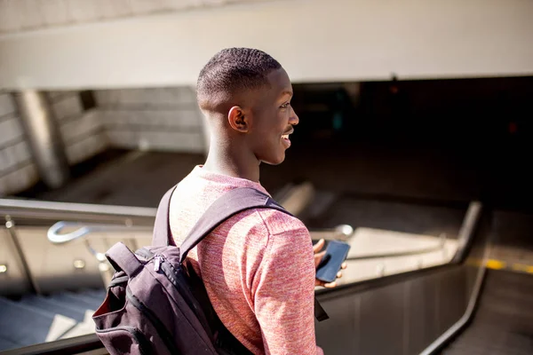 Retrato Detrás Joven Negro Bajando Escaleras Mecánicas Con Teléfono Móvil — Foto de Stock