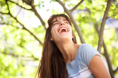 Parkta gülen genç kadının yakın portresi