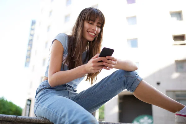 Портрет Молодой Женщины Сидящей Снаружи Смотрящей Мобильный Телефон — стоковое фото