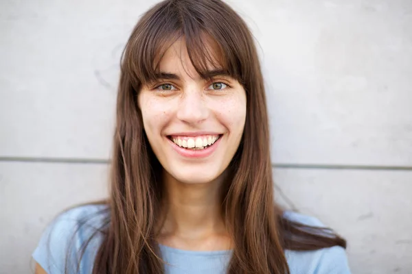 大きな笑顔と長い髪を持つ若い女性の正面の肖像画をクローズアップ — ストック写真