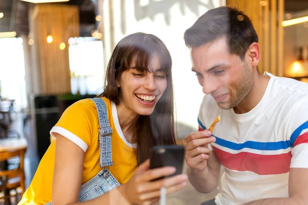 Portret Van Gelukkig Echtpaar Eten Kijken Naar Mobiele Telefoon Cafe — Stockfoto