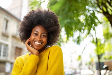 Şehrin dışında gülümseyen afro saçlı mutlu zenci kız portresi