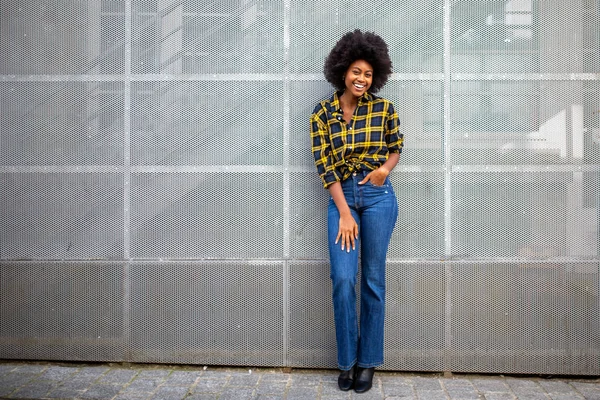 Full body portrait of stylish young african american woman with afro smiling