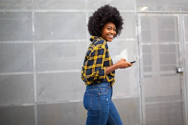 Бічний Портрет Усміхненої Молодої Чорної Жінки Пішохідною Ходою Триманням Мобільного — стокове фото