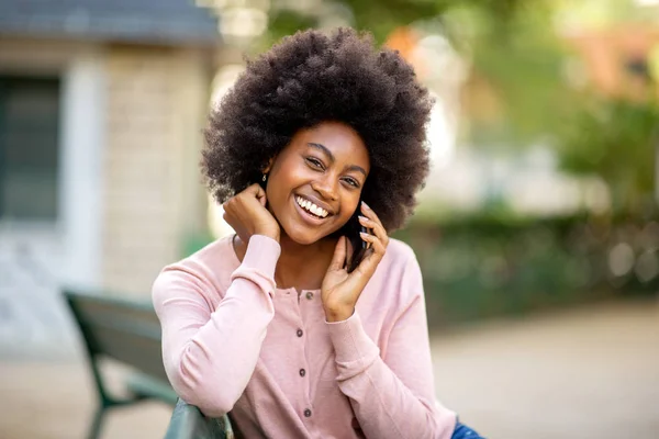 笑顔若いですアフリカ系アメリカ人女性とともにAfro毛の話とともに携帯電話 — ストック写真