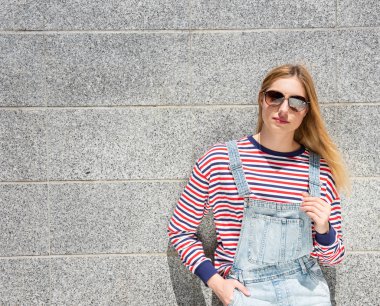 Güneş gözlüklü havalı sarışın genç kızın portresi.