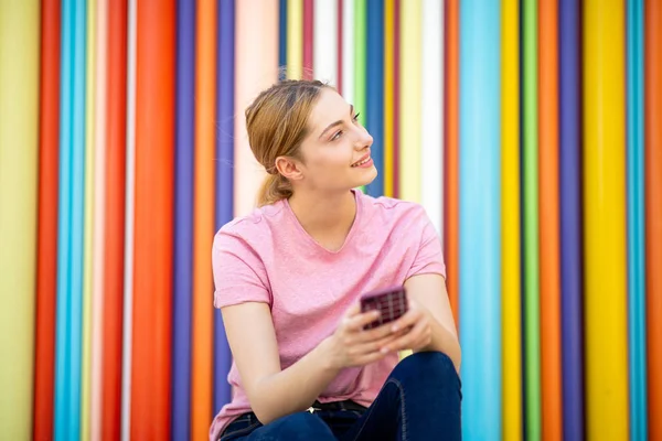 Portret Uśmiechniętej Nastolatki Trzymającej Telefon Przez Kolorowe Tło — Zdjęcie stockowe