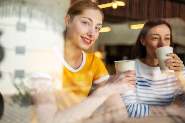 Anne ve kızının kafeteryada oturup kahve içerkenki portresini kapat.