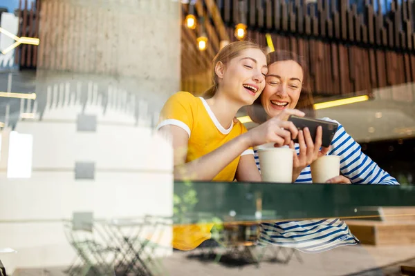 Retrato Madre Hija Riendo Cafetería Mirando Juntos Teléfono Celular —  Fotos de Stock