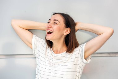 Yaşlı bir kadının yakın portresi kafasının arkasından gülüyor.