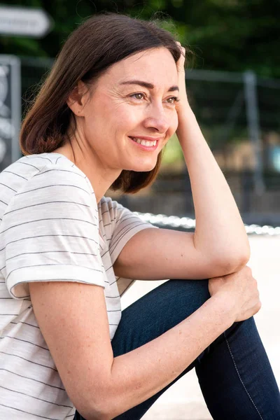 魅力的な中年女性の肖像座っと笑顔 — ストック写真