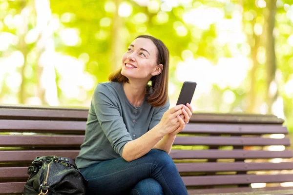 Portret Gelukkige Vrouw Zitten Het Park Met Mobiele Telefoon — Stockfoto