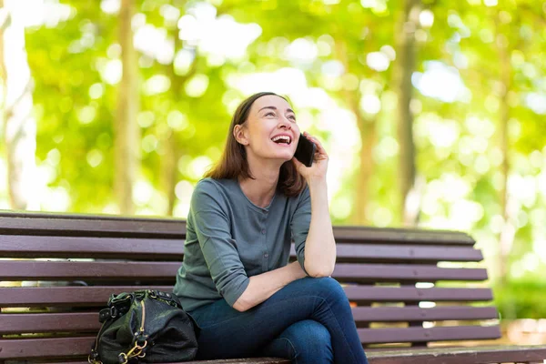 Portrait Femme Heureuse Assise Sur Banc Parc Parlant Avec Téléphone — Photo