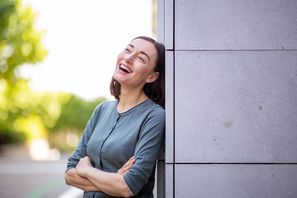 Portrait Beautiful Older Woman Leaning Wall Laughing Arms Crossed — Stockfoto