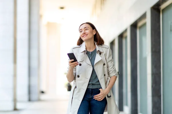Retrato Una Mujer Mayor Sonriente Caminando Con Teléfono Celular Afuera —  Fotos de Stock