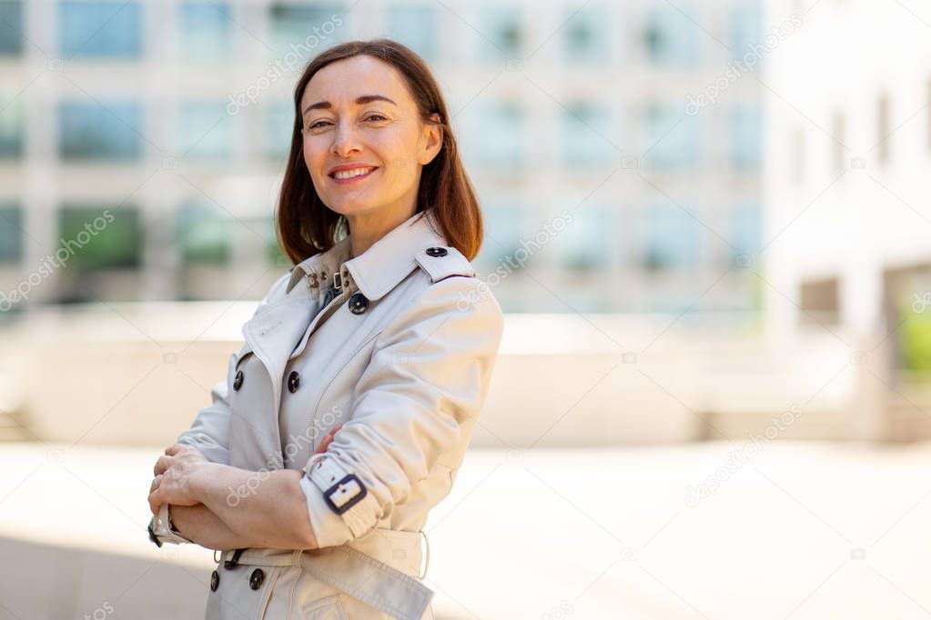 Portrait of confident older woman smiling outside in city
