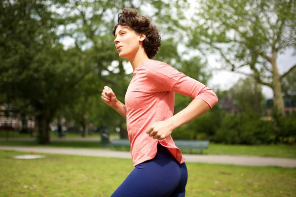 公園を走る女性のサイドポートレート — ストック写真