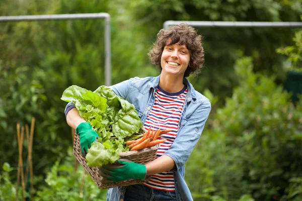 籠の中で野菜の束で微笑む女性農家の肖像画 — ストック写真