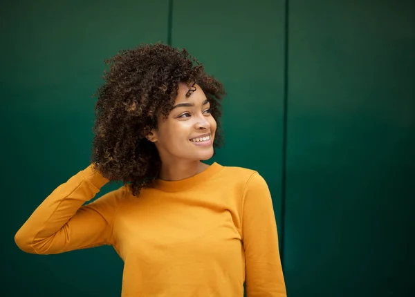 緑の背景によって髪に手で笑顔美しい若いアフリカ系アメリカ人女性の肖像画 — ストック写真