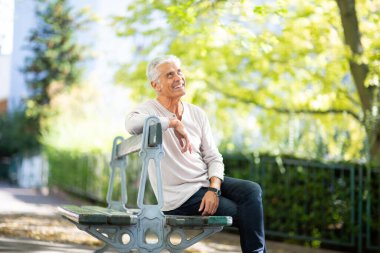 Parktaki bankta oturan mutlu adam portresi. 