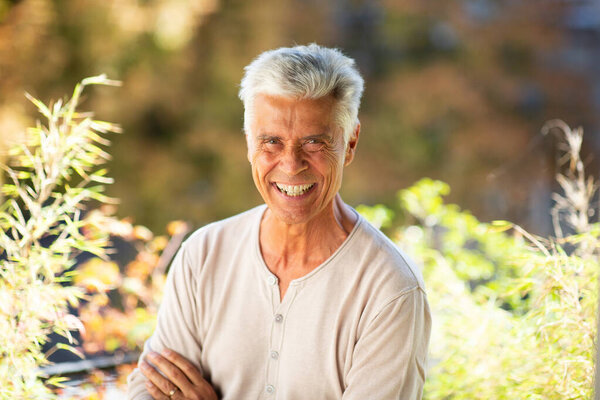 Close up portrait handsome older man smiling outdoors