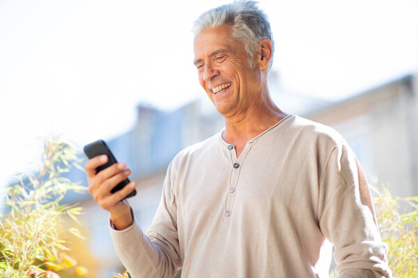 Close up portrait handsome older man looking at cellphone