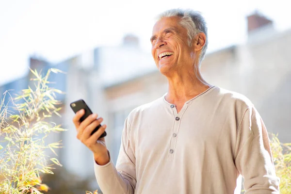 Portrait handsome older man laughing with mobile phone