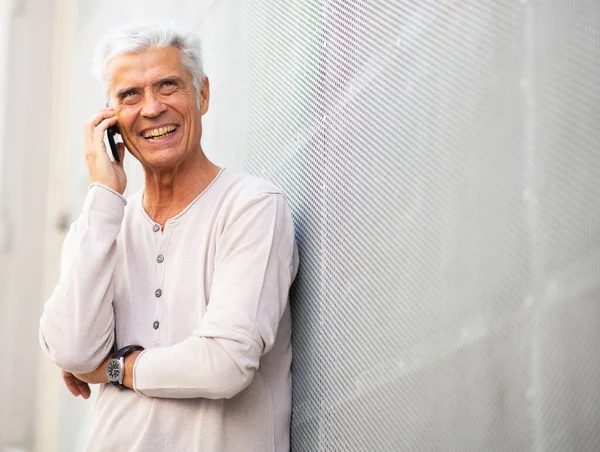 Portrait happy older man talking with cellphone outside