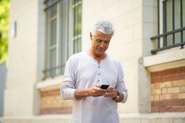Portret Starszego Mężczyzny Patrzącego Telefon Komórkowy Mieście — Zdjęcie stockowe