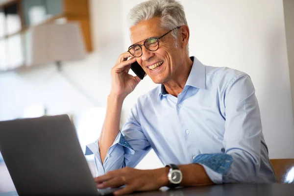 Zamknij Portret Uśmiechnięty Biznesmen Rozmawiający Telefonem Podczas Oglądania Laptopa — Zdjęcie stockowe