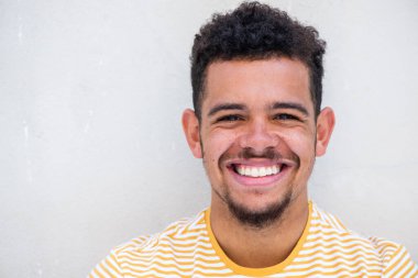 Beyaz arka planda sakallı, mutlu, melez bir gencin portresini yakın çekelim.