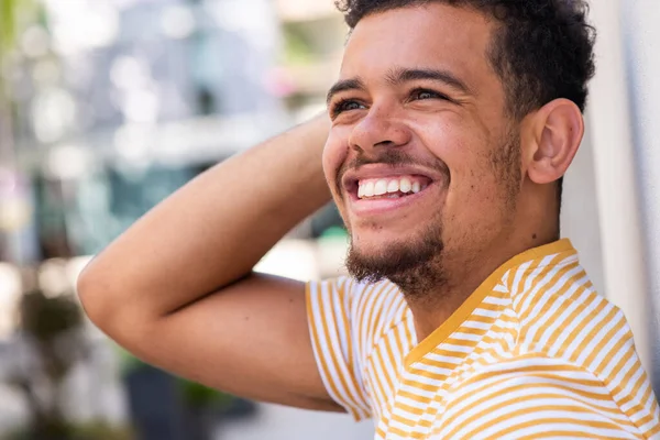 Close up side portrait of happy young mixed race man with hand behind head