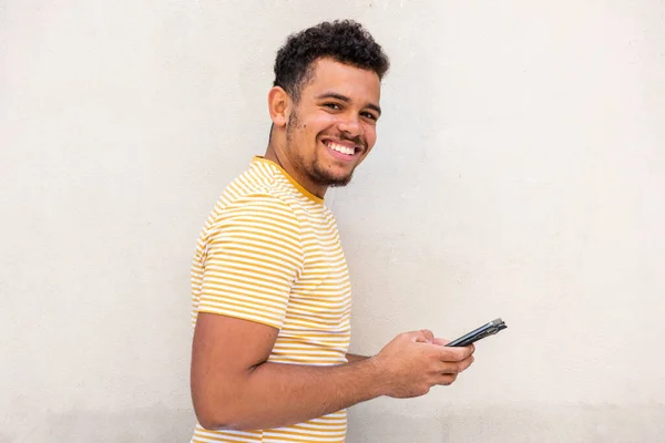 Sidoporträtt Glad Ung Blandras Man Vit Vägg Håller Mobiltelefon — Stockfoto