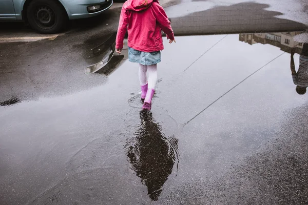 feet girls run through puddles in rubber boots