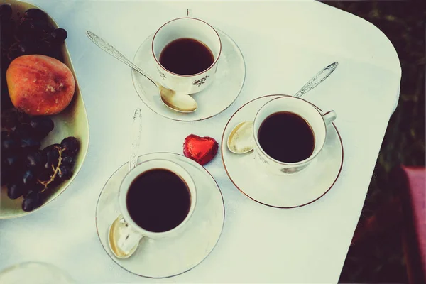 3 bardak kahve kaşık bir tablo ile bir daire üzerinde stand