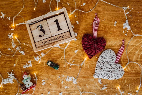 31 Aralık için tahta takvim. Karda iki kalp var.