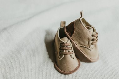 Yeni doğmuş bebek ayakkabılar ve bağcıklar beyaz arka planda fotokopi alanı ile birlikte. Bebek moda konsepti