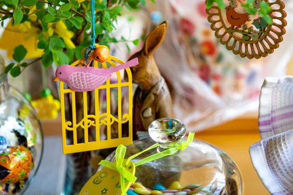 Decorated dining table. Easter holiday, Easter table, figurines of hares and festive cupcakes. Decorated branches