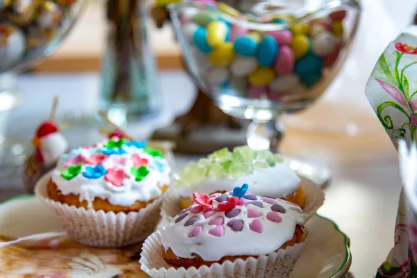 Decorated dining table. Easter holiday, Easter table, figurines of hares and festive cupcakes. Decorated branches