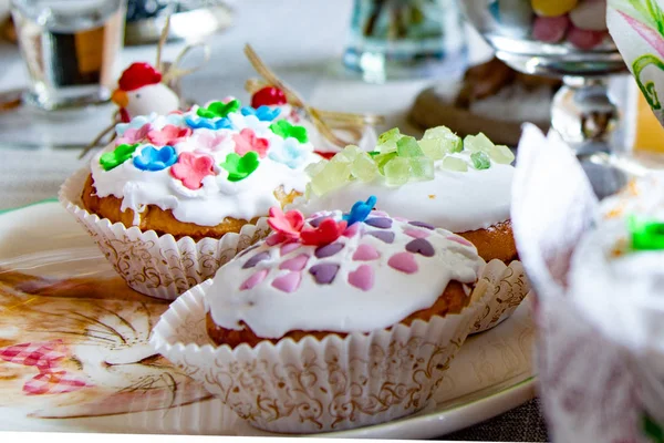 Decorated dining table. Easter holiday, Easter table, figurines of hares and festive cupcakes. Decorated branches