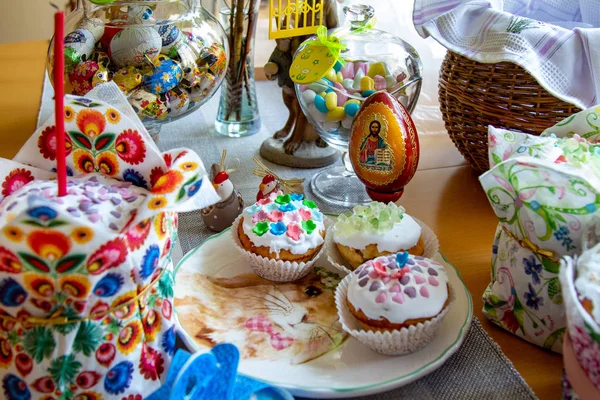 Decorated dining table. Easter holiday, Easter table, figurines of hares and festive cupcakes. Decorated branches