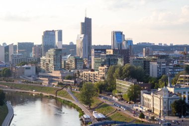 Gün batımında Vilnius Panoraması. Şehir binaları. Ufuktaki gökdelenler. Şehrin üzerinde mavi gökyüzü. Gün batımında bulutlar ve güneş. Yaz akşamı. Hafta sonu sakin bir gün.