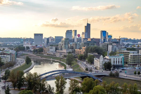 Gün batımında Vilnius Panoraması. Şehir binaları. Ufuktaki gökdelenler. Şehrin üzerinde mavi gökyüzü. Gün batımında bulutlar ve güneş. Yaz akşamı. Hafta sonu sakin bir gün.