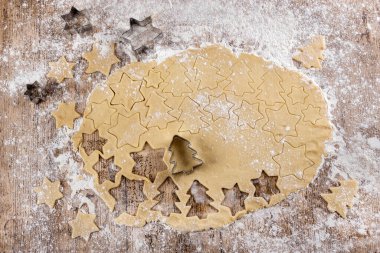 Çiğ hamurun noel ağacı ve yıldızlara benzeyen kurabiyeler yapmak için kesilmiş halinin en üst görüntüsü. Yukarıdan bak. Komik yemek. Çocuklar için yemek tarifleri. Noel tatlısı