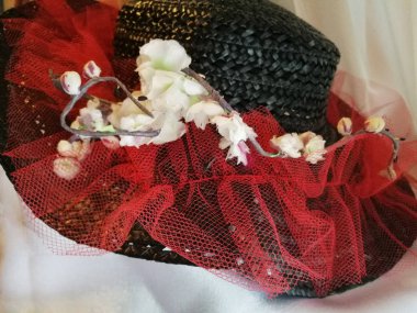 kadın mavi şapka ile ağzına kadar beyaz çiçekler kırmızı kurdele ile süslenmiş 