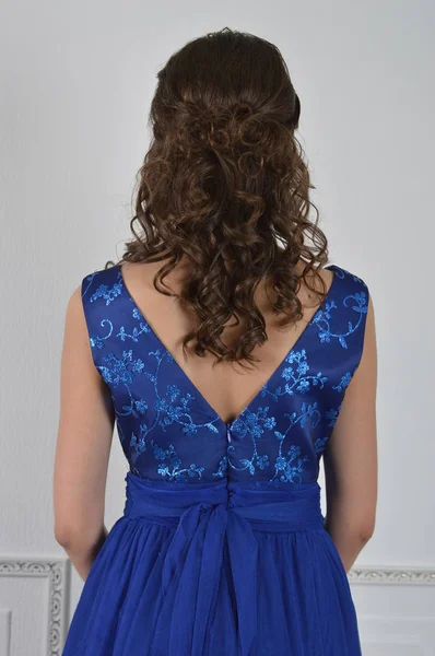 Dziewczynka stoi w piękna niebieska sukienka z długimi włosami wi — Zdjęcie stockowe