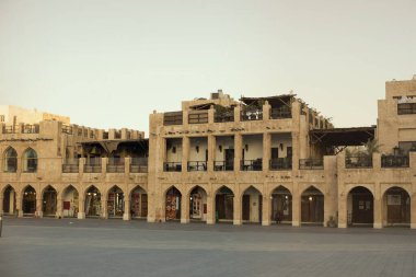 Souq Waqif karantina sırasında. Marketin önündeki boş alan. Dükkanlar ve kafeler çalışmıyor. Gün batımı. Turuncu Gökyüzü Camii