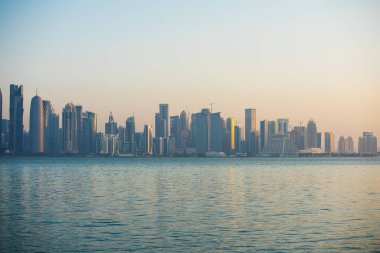 Doha 'nın şafağı. Şehir merkezinin manzarası. Güneş ışınları bir açıyla geriye doğru yükselir. Batı Körfezi